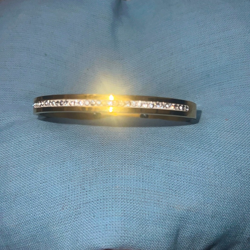 This is a gold bracel with a claps opening.